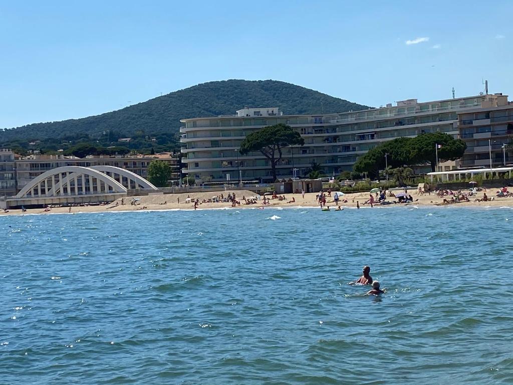 une personne nageant dans l'eau près d'une plage dans l'établissement Apartment Genius Superior Ste Maxime 307, à Sainte-Maxime