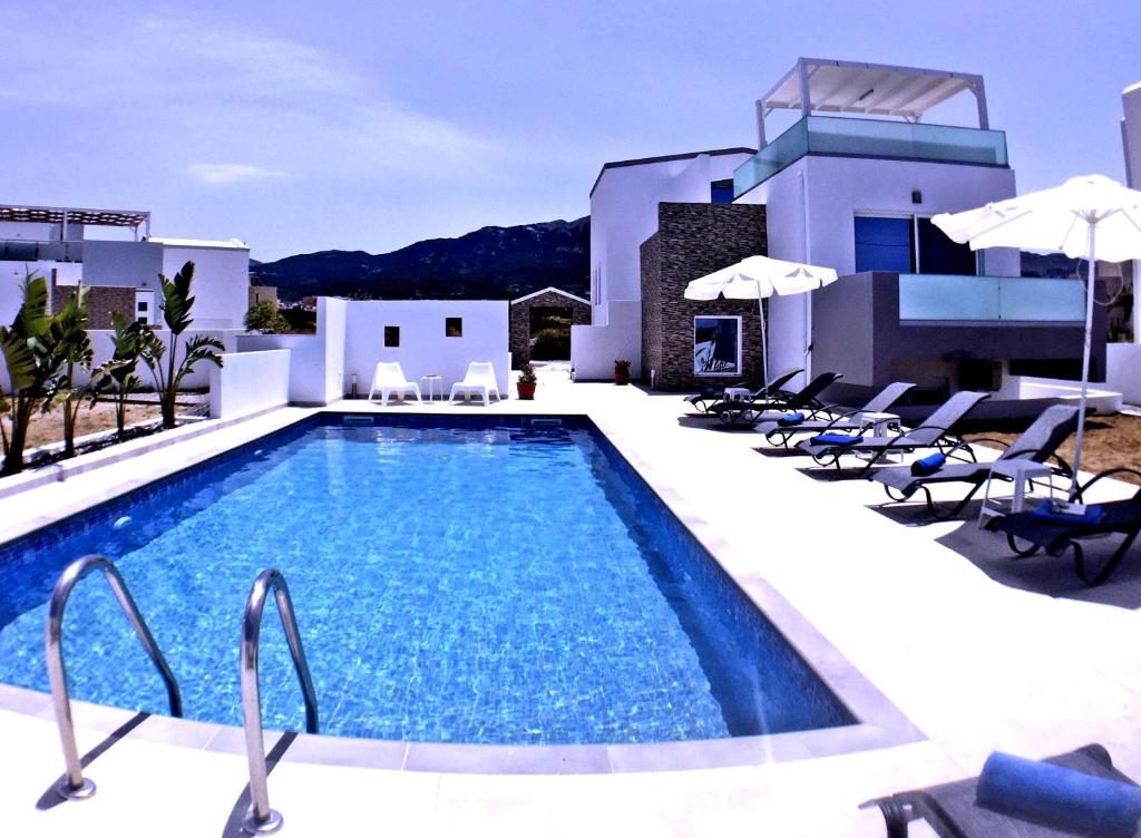 a swimming pool in front of a villa at Xenos Villa 4 - Luxury Villa With Private Swimming Pool Near The Sea in Tigaki