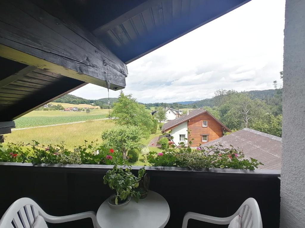 a balcony with a table and a view of a field at Haus Pieschl in Pertitschach