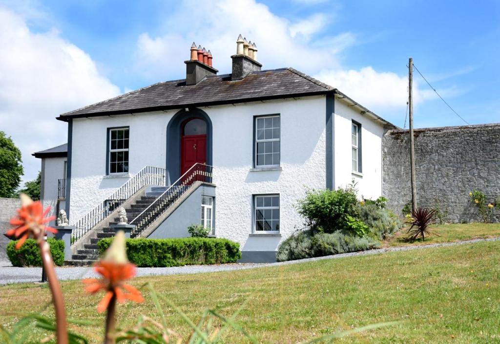 a white house with a red door at Nore View House in Kilkenny