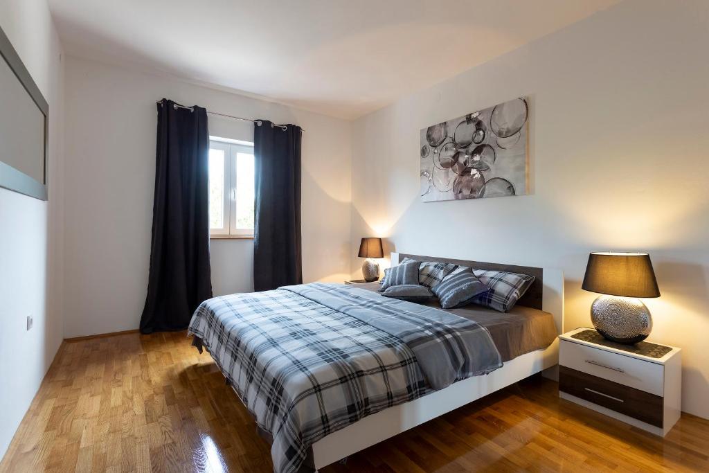Łóżko lub łóżka w pokoju w obiekcie APARTMANI KAROCA 3