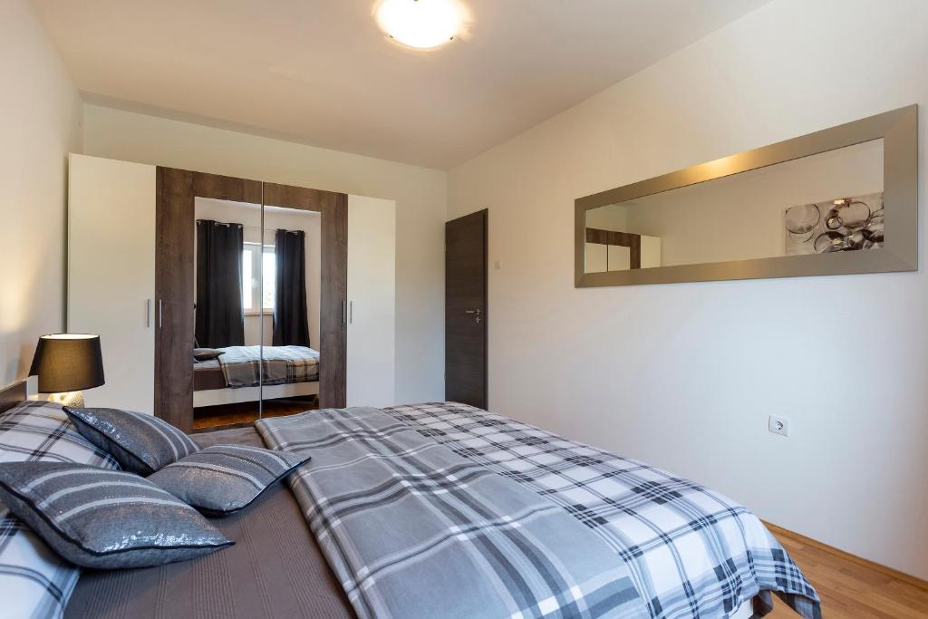Łóżko lub łóżka w pokoju w obiekcie APARTMANI KAROCA 3