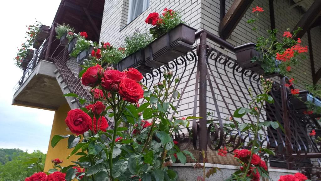 a balcony with red flowers on a house at Apartmani Mali Raj Rudnik in Rudnik