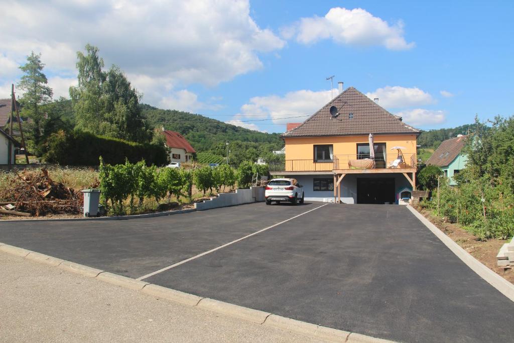 a car parked in a parking lot next to a house at le chemin du meunier in Riquewihr