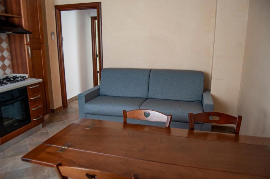 ein Wohnzimmer mit einem blauen Sofa und einem Tisch in der Unterkunft Appartamenti Medusa in Alba Adriatica