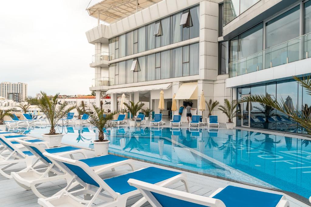 a swimming pool with chairs and a building at Boutique Hotel Portofino in Odesa