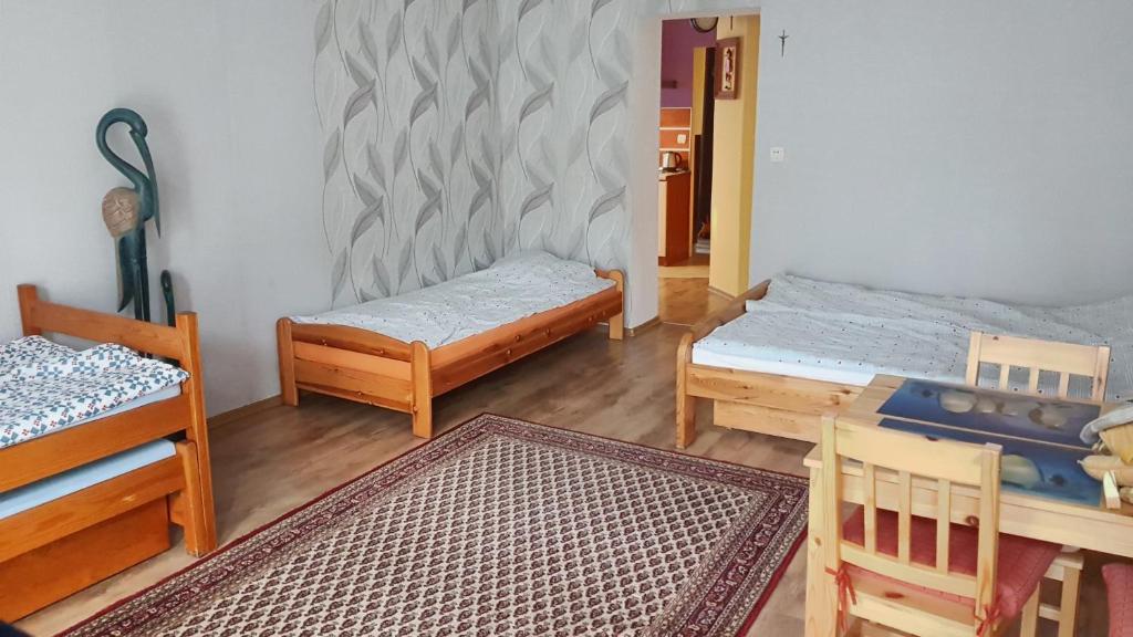 een kamer met twee bedden en een tafel en stoelen bij Studio Ania in Stegna