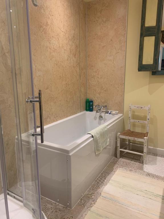 a bathroom with a tub and a glass shower at The Old Deer House in Bodmin