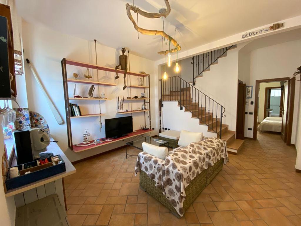a living room with a couch and a staircase at Camere Frangimare in Porto Recanati