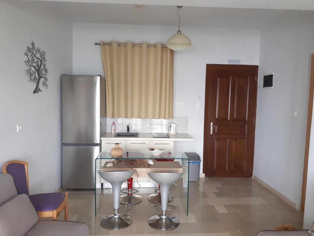kuchnia ze szklanym stołem i lodówką w obiekcie Superior Suite Cronus w mieście Vassilias