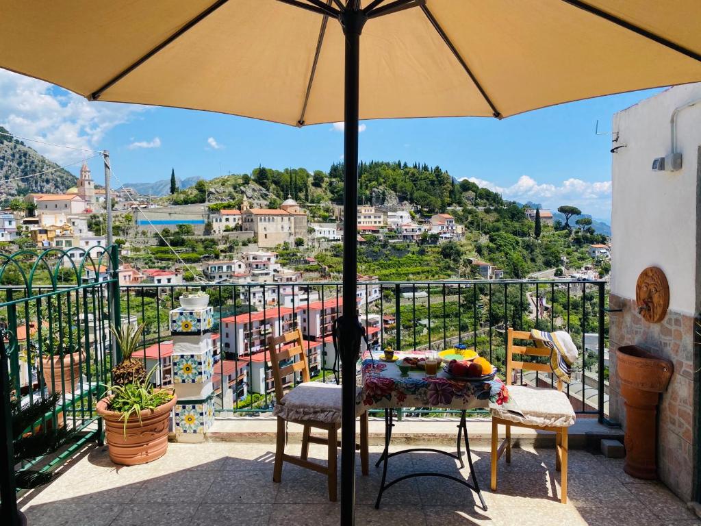 un tavolo con ombrellone in cima a un balcone di Lucy's house - comfortable apartment in Amalfi ad Amalfi