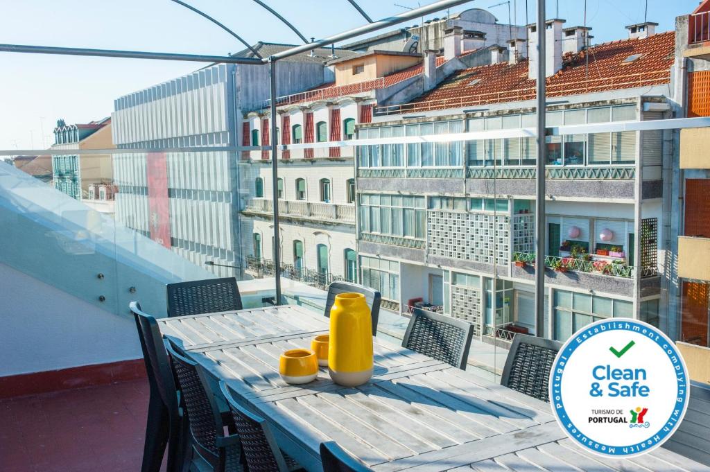 a table with yellow containers on it on a balcony at Angel's Duplex Terrace Five Bedrooms in Lisbon