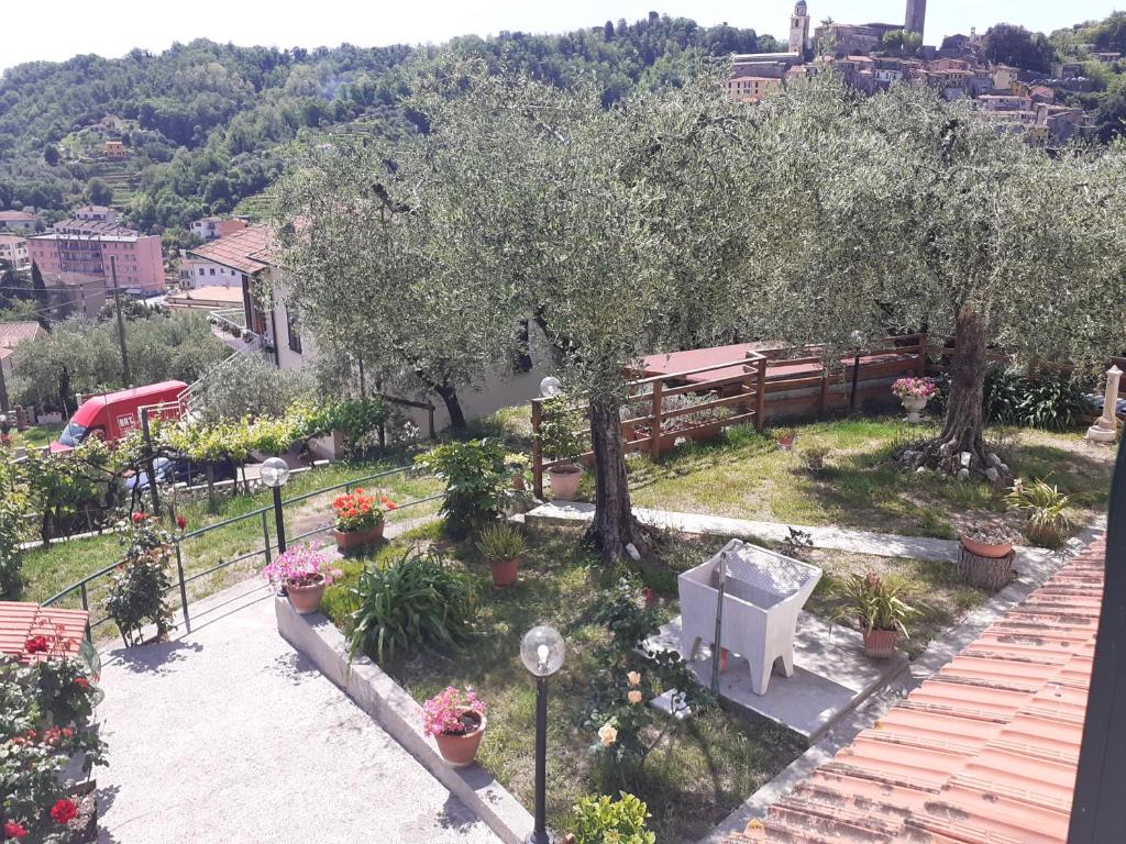 a garden with trees and flowers and a bench at casetta del nonno bis in Arcola