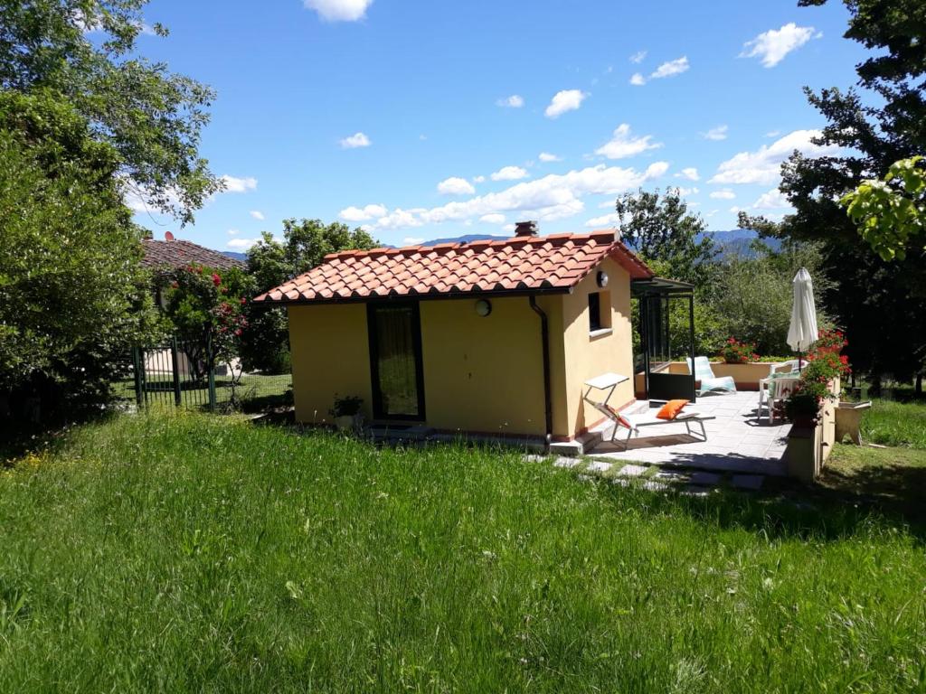 une petite maison jaune dans un champ d'herbe dans l'établissement La casetta nel prato, à Vicchio