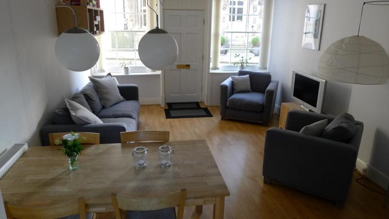 uma sala de estar com uma mesa com copos de vinho em Totters townhouse em Caernarfon