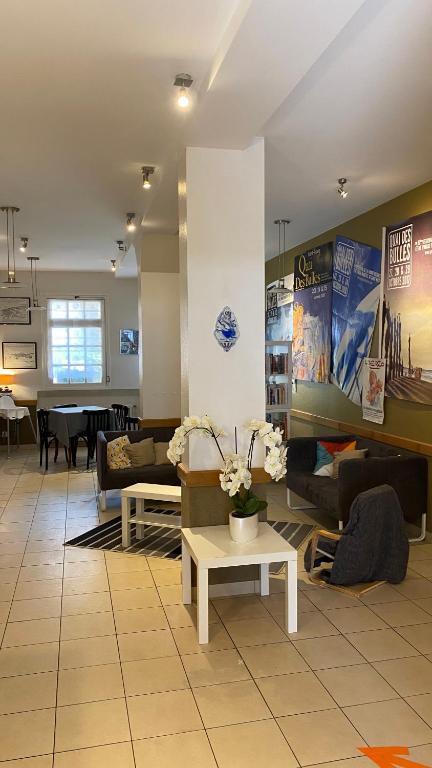 a living room with couches and a table at Hôtel La Porte Saint Pierre-Logis Hôtel Intra Muros in Saint Malo