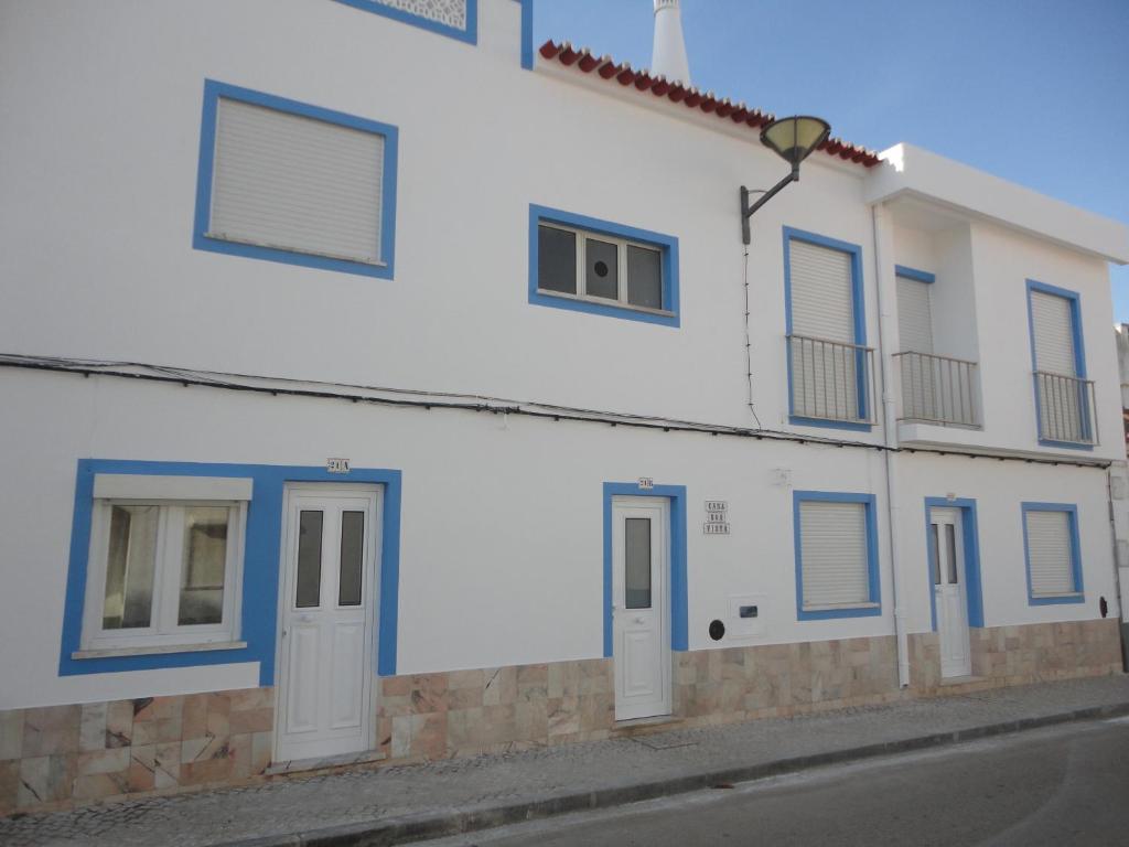 a white building with blue doors and windows at Casa Boa Vista in Burgau