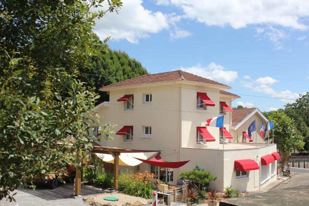 un edificio con sombrillas rojas y azules delante de él en Hôtel du Lac d'Arjuzanx, en Arjuzanx