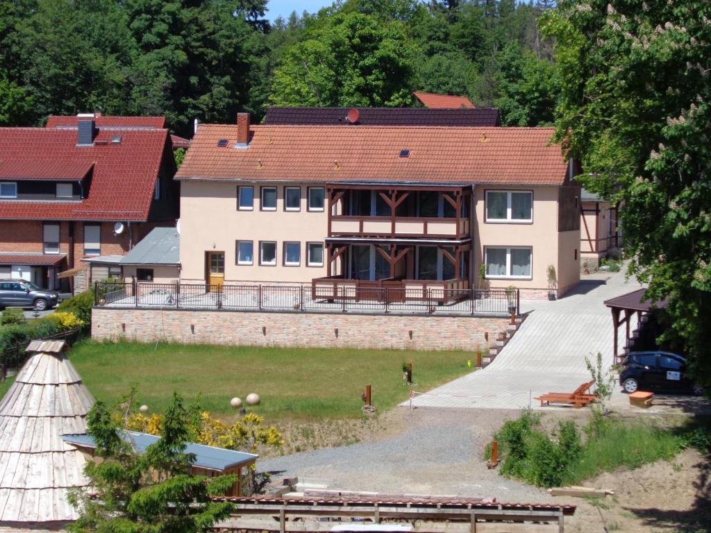 una casa grande con un gran patio delante en Harz Pension en Friedrichsbrunn