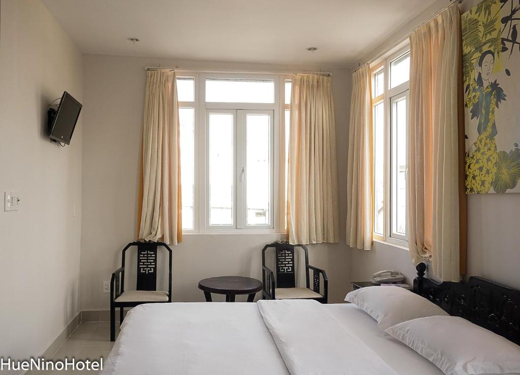 Postel nebo postele na pokoji v ubytování Hue Nino Hotel