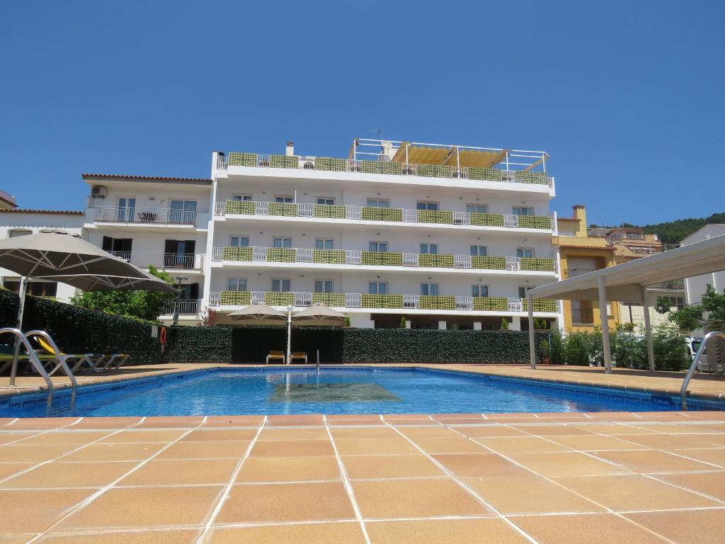 um hotel com piscina em frente a um edifício em Hotel Santa Anna em L'Estartit