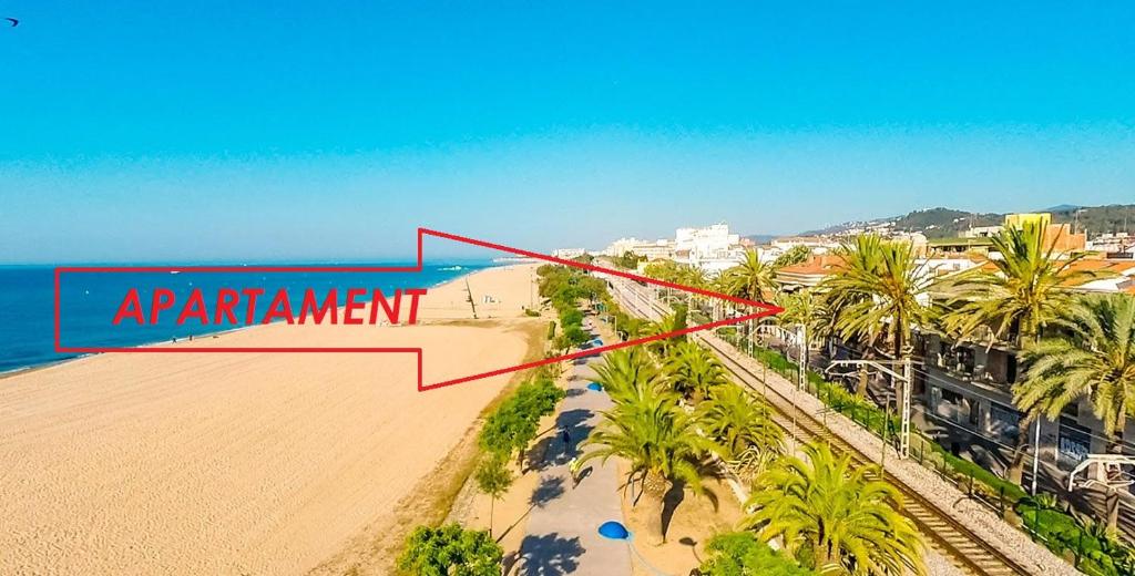 een luchtzicht op een strand met een bord dat experiment leest bij EIVISSA in Malgrat de Mar
