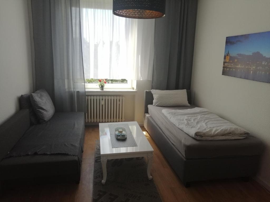 um quarto com uma cama, um sofá e uma mesa em Wohnung in Köln em Colónia