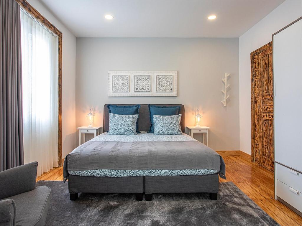um quarto com uma cama grande e almofadas azuis em Porto Je T'aime - Sweet Rooms em Vila Nova de Gaia