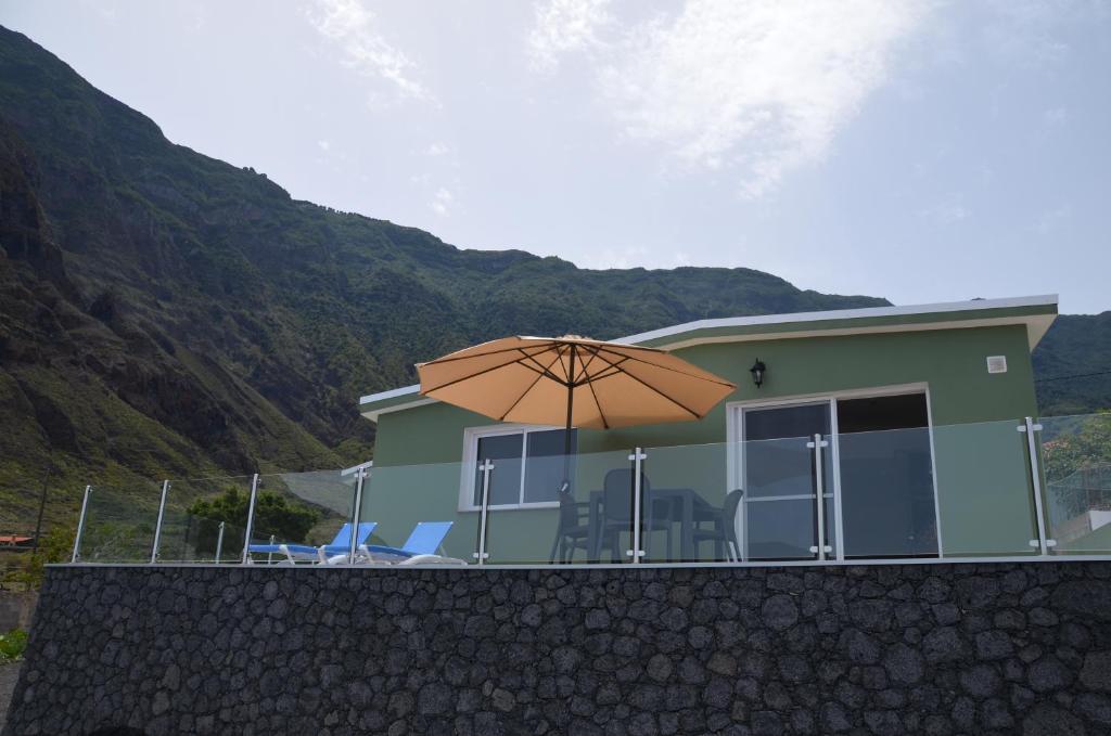 uma casa com um guarda-chuva em frente em CASA MIRAMAR FRONTERA em Frontera