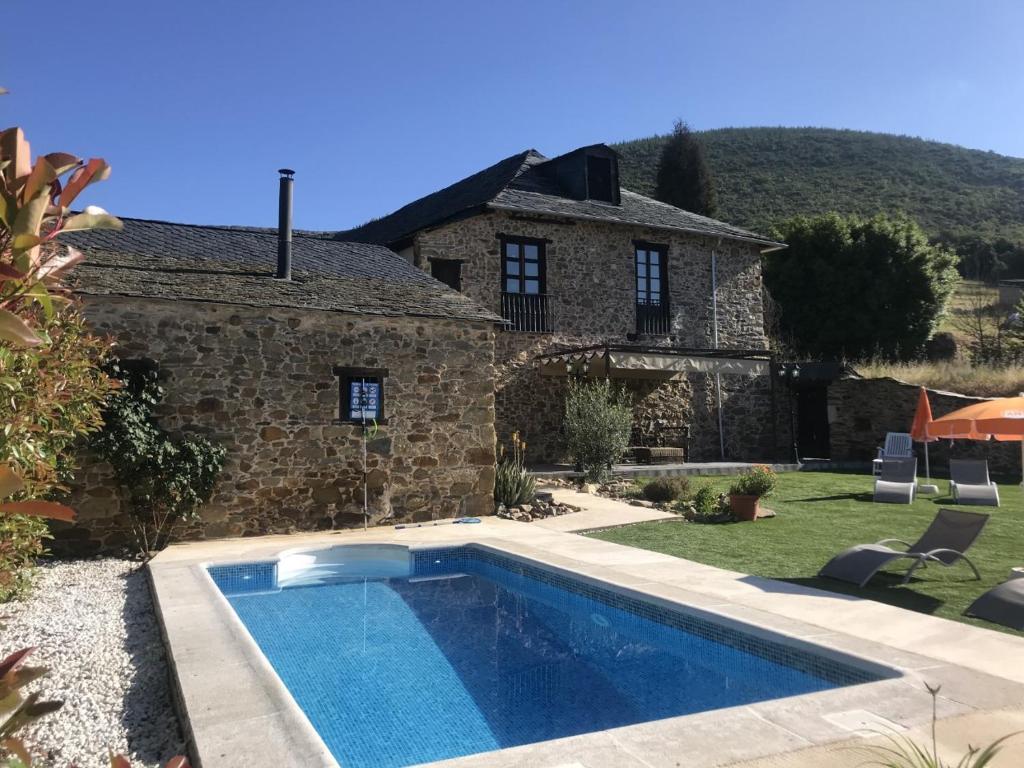 a swimming pool in front of a stone house at La Casa Grande Del Valle in El Valle