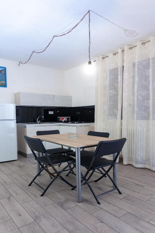 a kitchen with a table and chairs in a kitchen at aestatisdomus in Uggiano la Chiesa