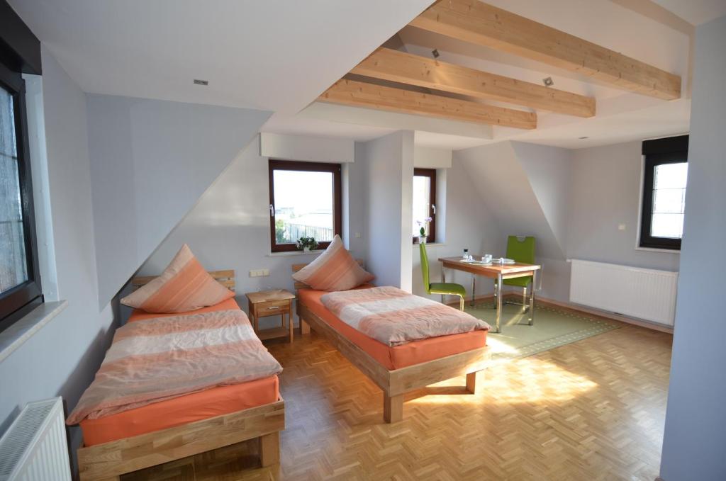 a attic room with two beds and a table at Ferienwohnung Bouten B in Geldern