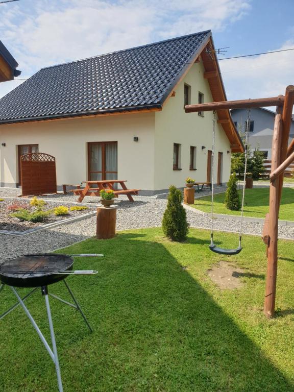una casa con un patio con un columpio en Domki Urbaczka w Istebnej, en Istebna