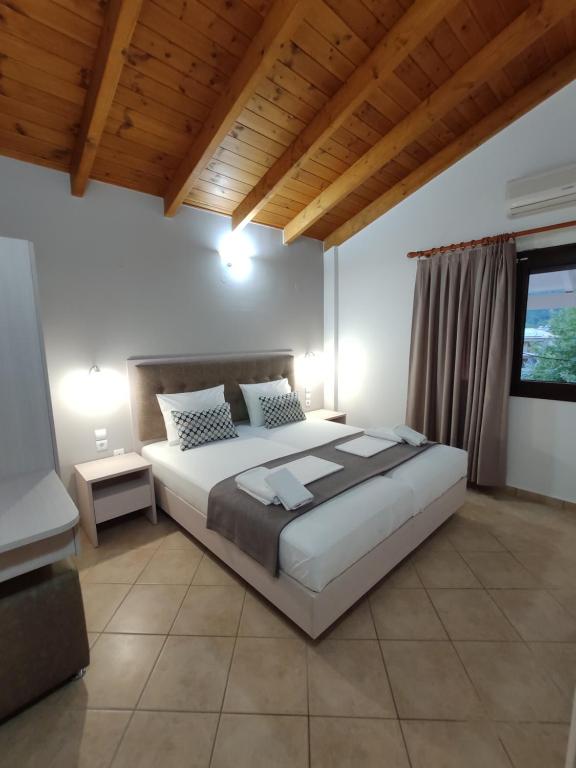 a bedroom with a large bed and a window at Villa Dimitris in Parga