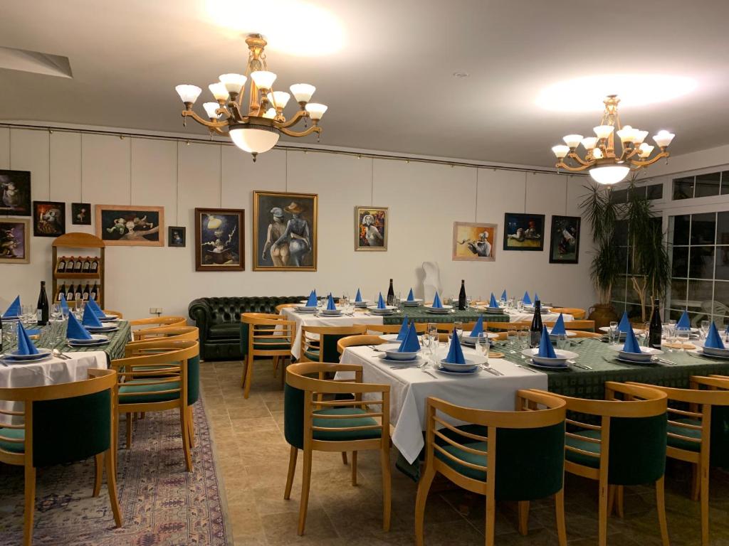 a dining room with tables and chairs with blue napkins on them at Antik Hotel Sofia in Litomyšl