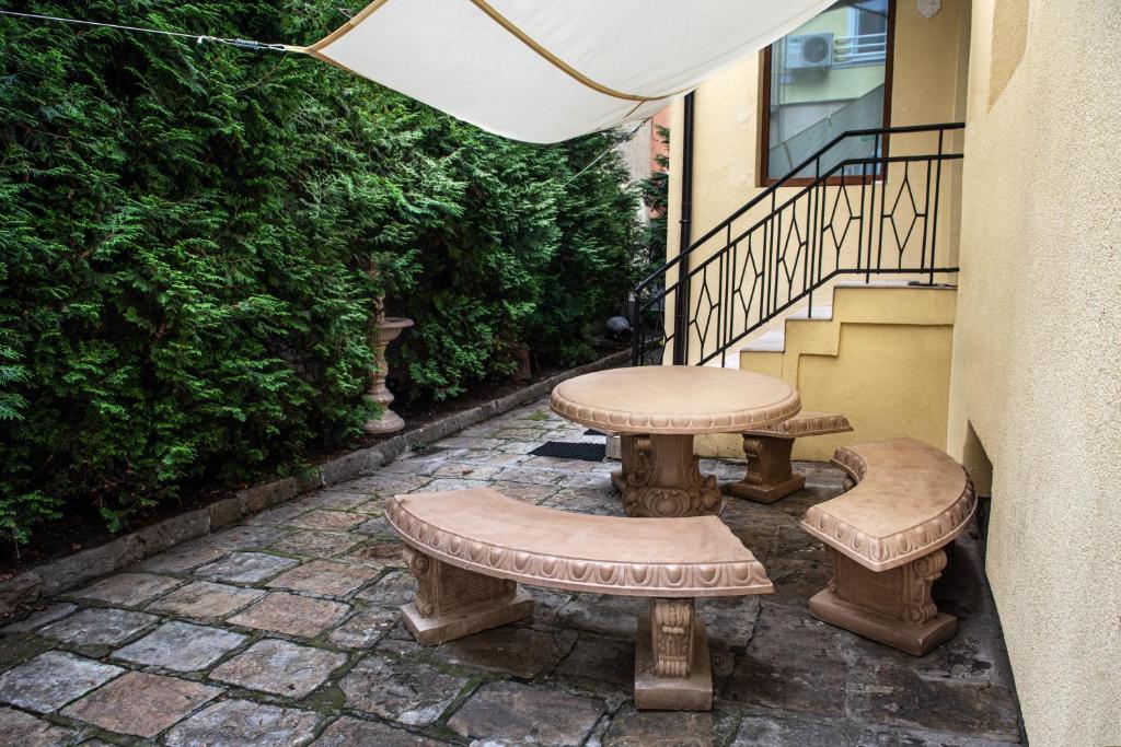 a patio with two benches and a table at Social Guest House in Sofia