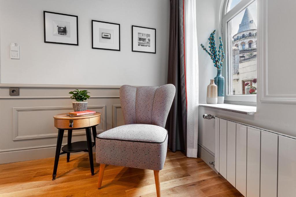 a chair and a table in a room with a window at World House Boutique Hotel Galata in Istanbul