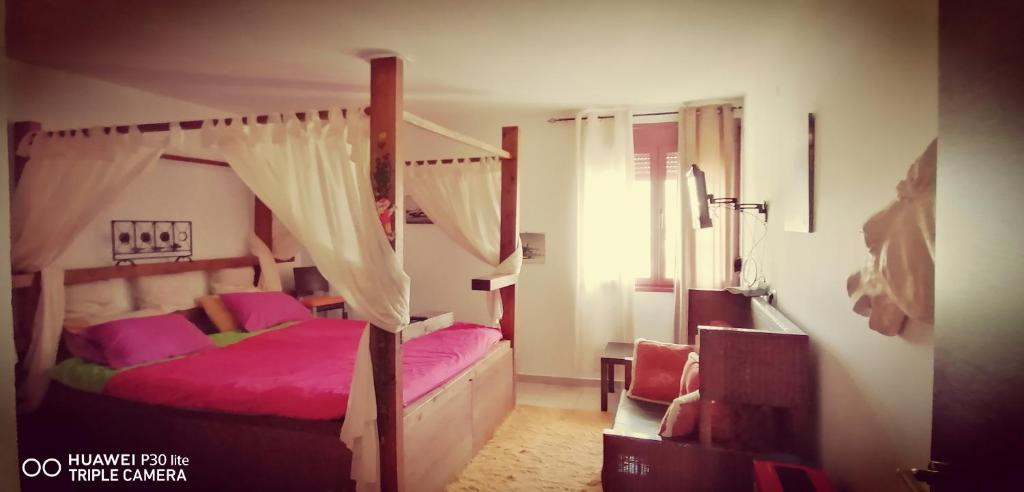 sypialnia z łóżkiem z baldachimem i różową pościelą w obiekcie Rural hοuse w mieście Kastrítsa