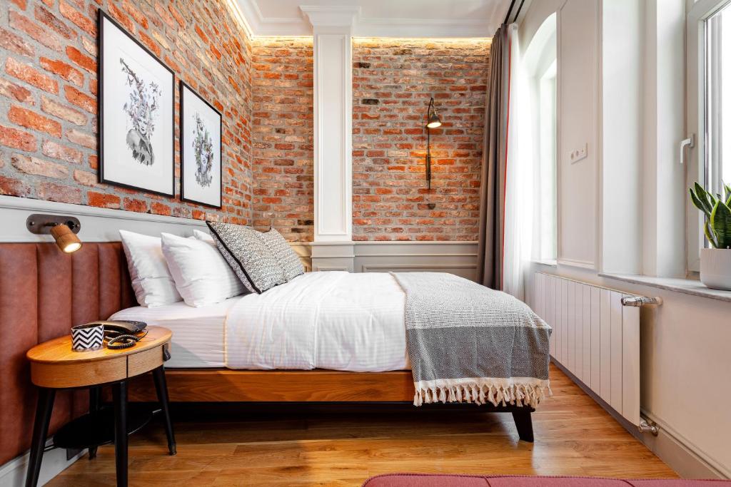 a bedroom with a bed and a brick wall at World House Boutique Hotel Galata in Istanbul