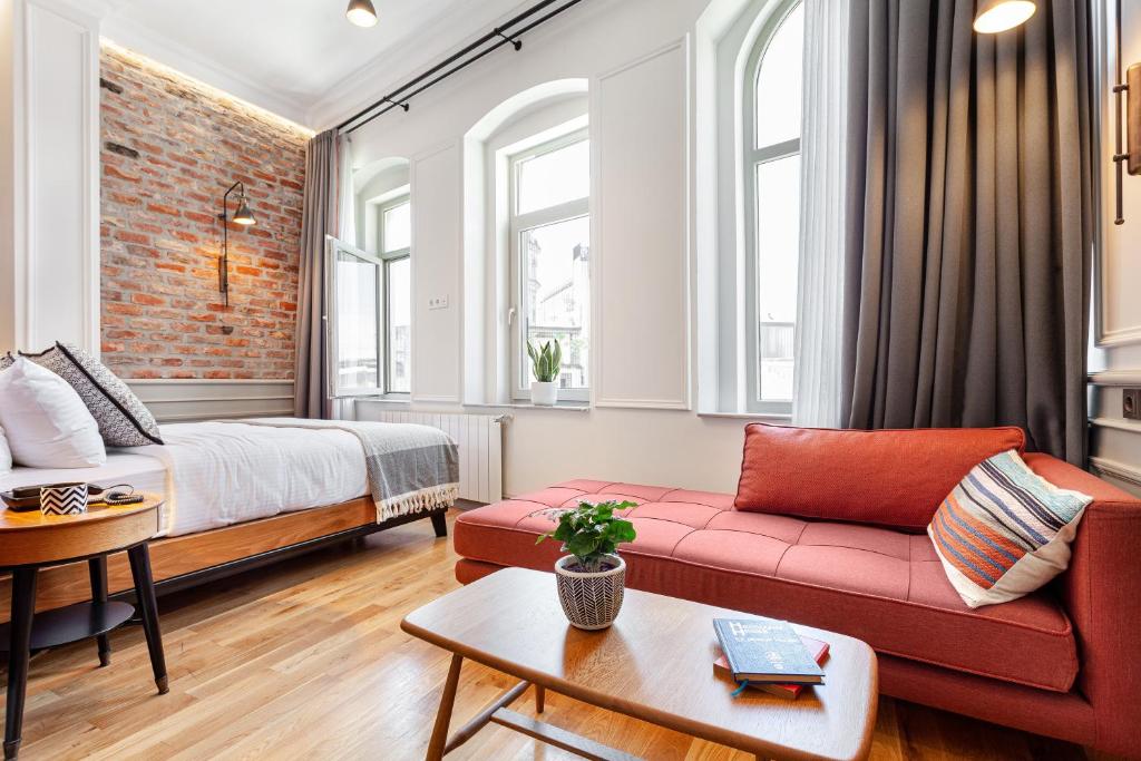 a living room with a red couch and a bed at World House Boutique Hotel Galata in Istanbul