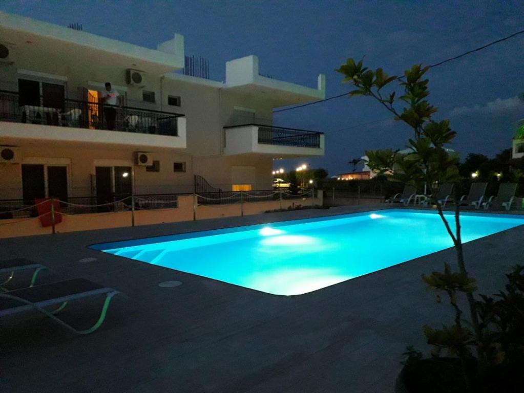 a swimming pool in front of a house at night at Nick Rooms in Stavros