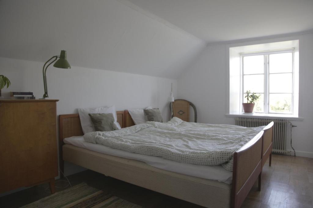 um quarto com uma cama e uma janela em Stora Mellings gård em Klintehamn