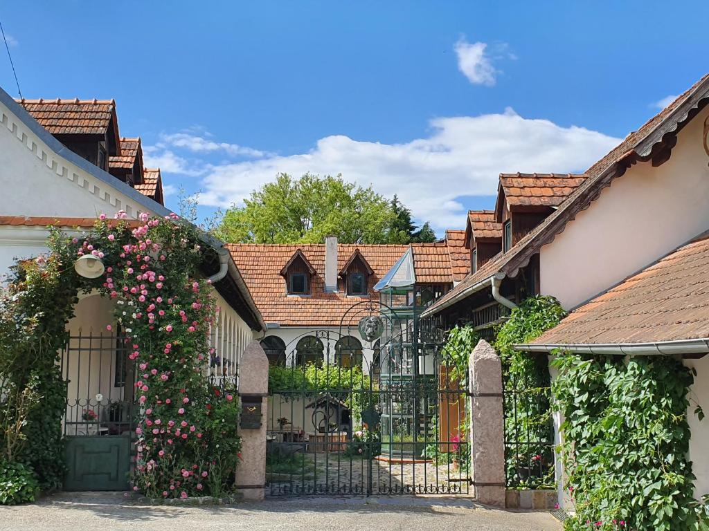 a wrought iron gate in a yard with roses at ArkadenSchlössl in Neudauberg
