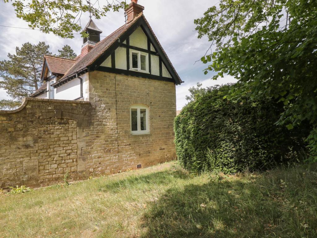 an old brick house with a roof at The Coach House in Stroud