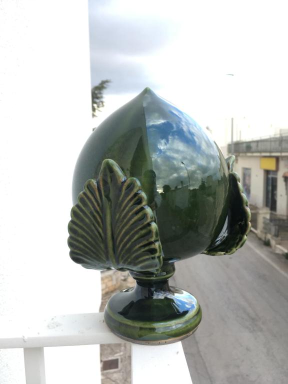 a green glass vase sitting on top of a table at La Torretta in Alberobello