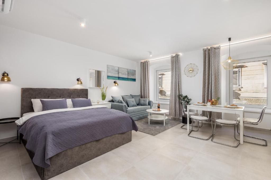 a bedroom with a bed and a living room at Srnec Apartments - Korzo in Rijeka