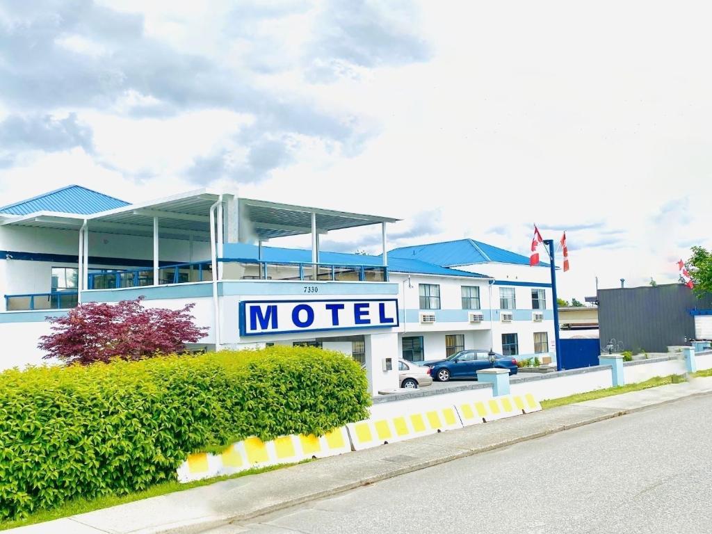 una señal de motel frente a un edificio en Happy Day Inn, en Burnaby