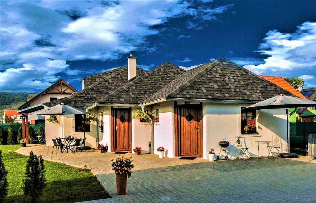 a large white house with a patio in front of it at Piemonti Bešeňová in Bešeňová