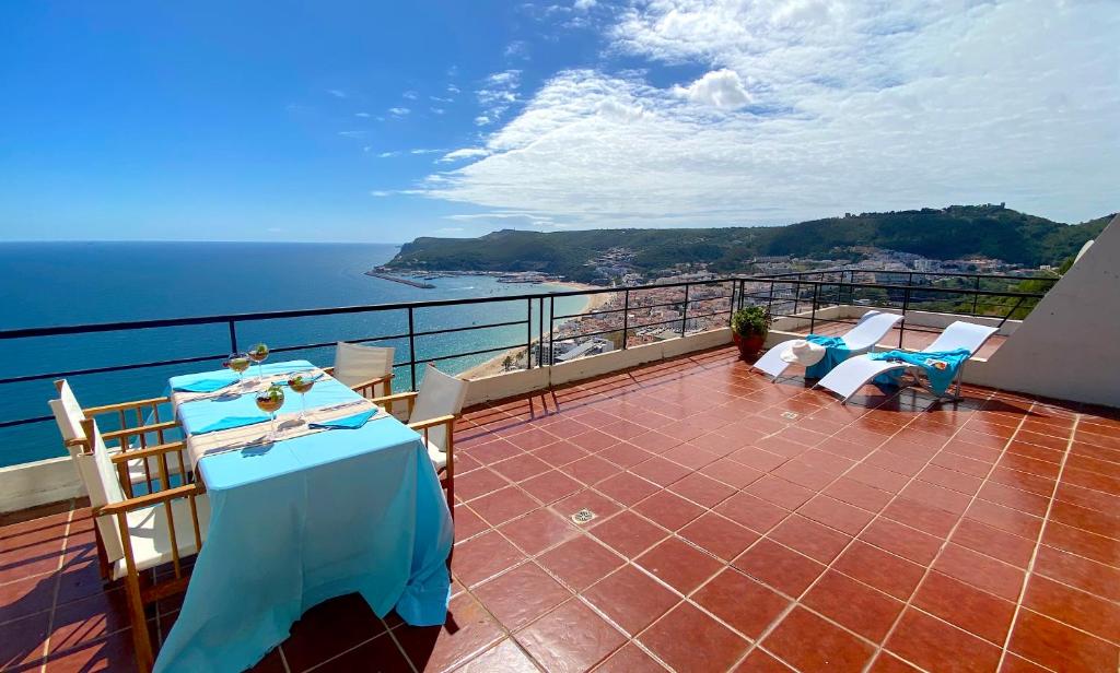 a balcony with a table and chairs and the ocean at Sea View Apartment Sesimbra- Apartamento Vista Mar in Sesimbra
