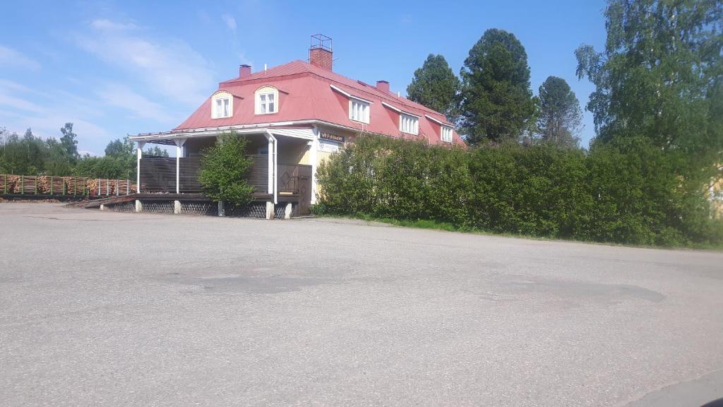 una casa grande con techo rojo en una calle en Asemantupa 2, en Pyhäsalmi
